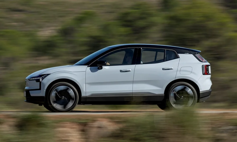 Фото Volvo EX30 — вид сбоку, фото 3. Сбоку читаются линия остекления и характер выштамповок на белом кузове Volvo EX30 — вид сбоку, фото 3