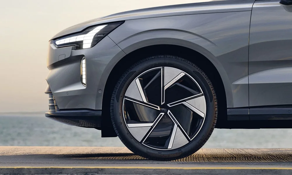Фото Volvo EX90 (2024) — вид сбоку, фото 3. Профиль в сером цвете: соотношение колёсной базы и свесов. Хромированные или чёрные молдинги окон отличают комплектации Volvo EX90 (2024) — вид сбоку, фото 3