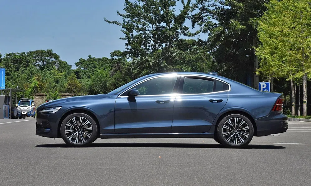 Фото Volvo S60 (2024) — вид сбоку, фото 3. Сбоку читаются линия остекления и характер выштамповок на синем кузове Volvo S60 (2024) — вид сбоку, фото 3