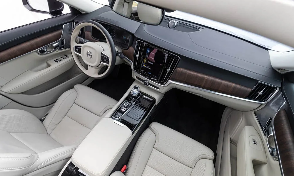 Фото Volvo S90 — передняя панель. Архитектура передней панели: ярусы, вставки и консоль в светлой бежевой гамме. Мягкие материалы верхнего яруса и вставки задают уровень интерьера Volvo S90 — передняя панель
