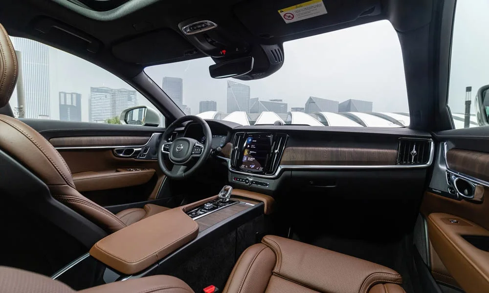 Фото Volvo S90 — интерьер, фото 2. Салон в коричневой отделке: архитектура передней панели, консоль и кресла. Уровень отделки читается по стыкам панелей и мягким поверхностям в зонах касания Volvo S90 — интерьер, фото 2