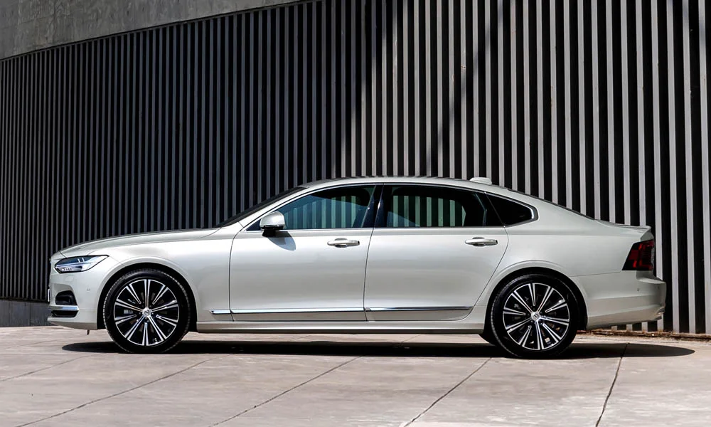 Фото Volvo S90 — вид сбоку, фото 2. Профиль кузова: колёсная база, свесы и линия остекления. Длинная база — простор второго ряда; короткие свесы упрощают парковку Volvo S90 — вид сбоку, фото 2