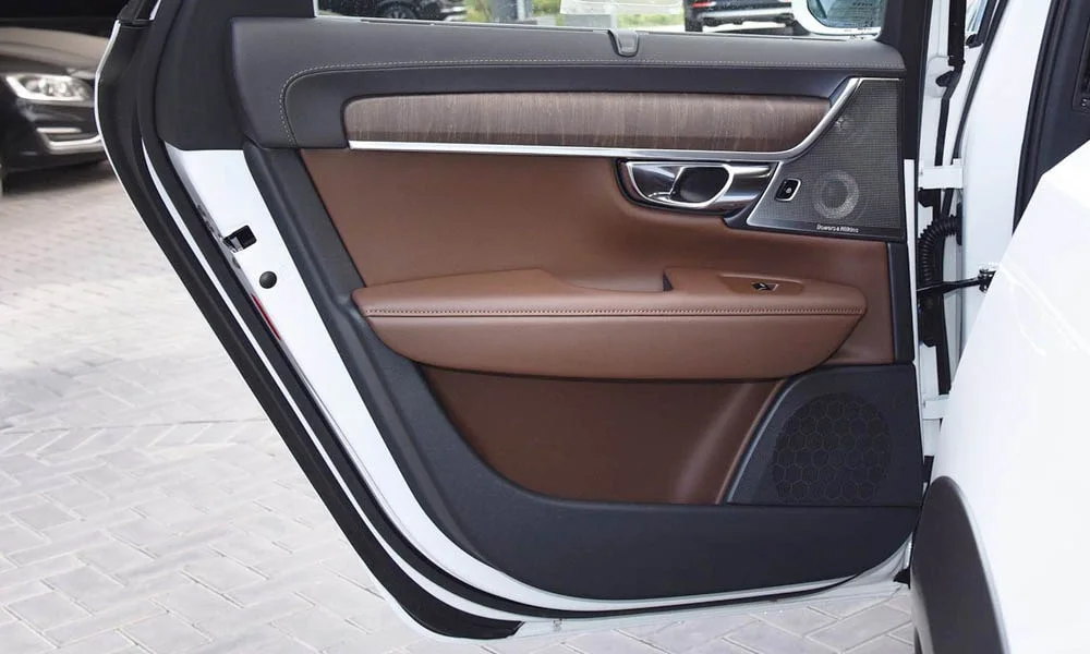 Фото Volvo V90 Cross Country — дверная карта, фото 3. Дверная карта в коричневой отделке: подлокотник, динамик и блок стеклоподъёмников. Решётка динамика в двери — часть штатной акустики Volvo V90 Cross Country — дверная карта, фото 3