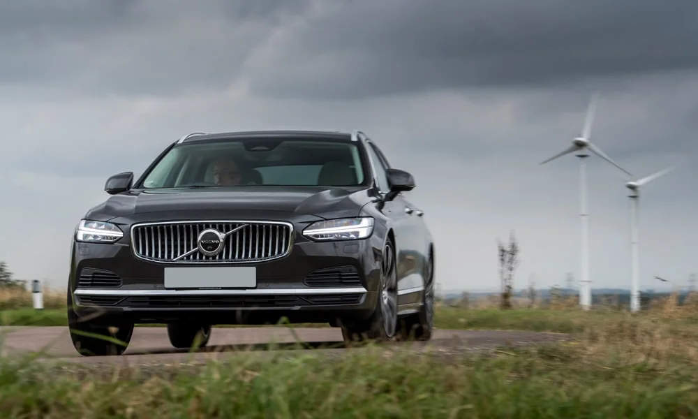 Фото Volvo V90 — вид спереди, фото 7. Чёрный кузов, строгая симметрия оптики — базовый ракурс знакомства с дизайном. Рисунок ходовых огней — подпись модели, по нему её узнают в потоке Volvo V90 — вид спереди, фото 7