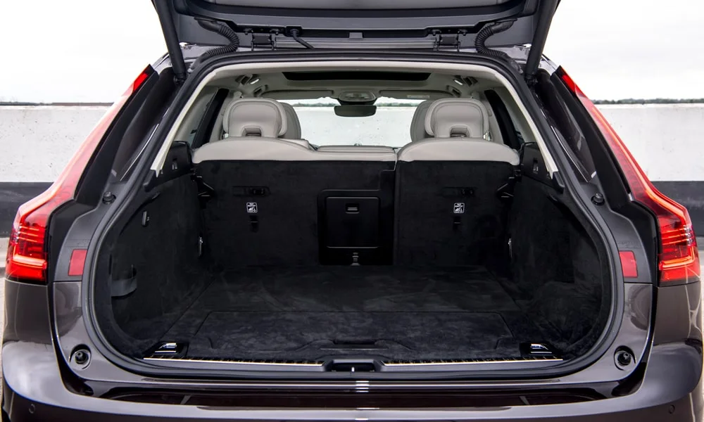 Фото Volvo V90 — багажник. Грузовой отсек с открытой дверью: погрузочная высота и ширина проёма. Под полом обычно размещены органайзер, докатка или ремкомплект Volvo V90 — багажник
