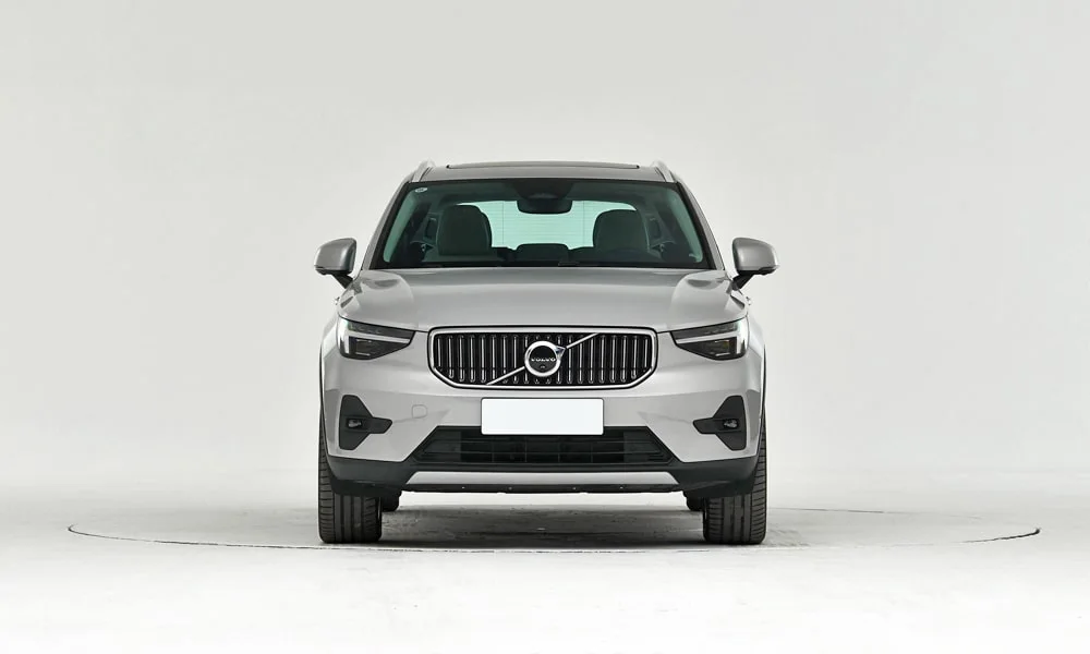 Фото Volvo XC40 (2024) — вид спереди, фото 4. Передок в сером исполнении — крупная светотехника и выразительный бампер. Рисунок ходовых огней — подпись модели, по нему её узнают в потоке Volvo XC40 (2024) — вид спереди, фото 4
