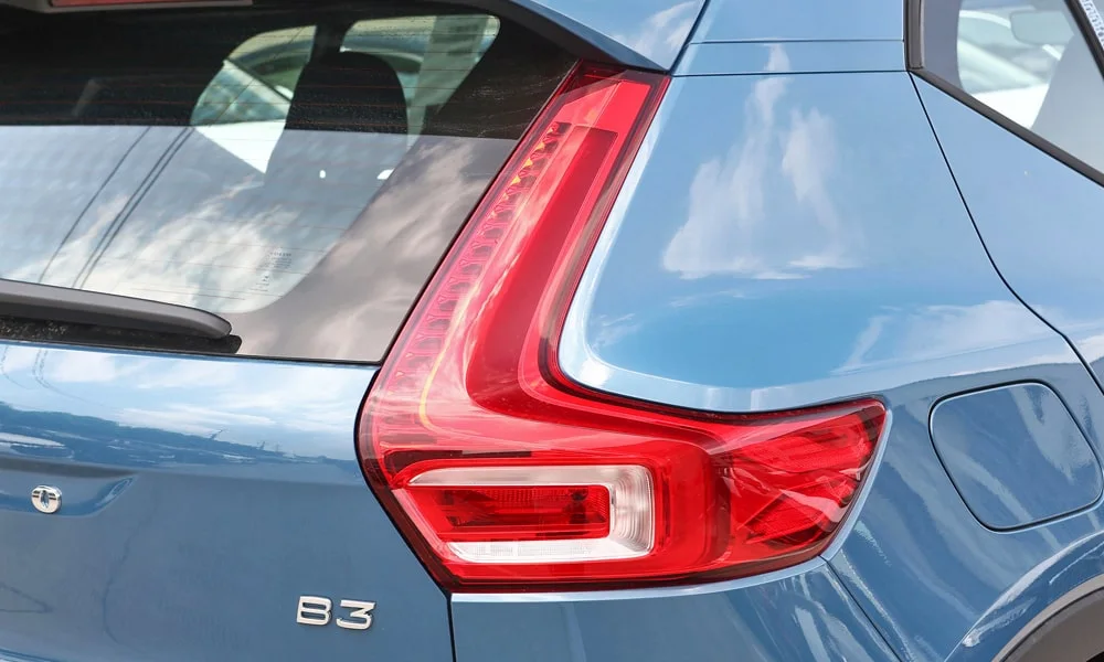 Фото Volvo XC40 (2024) — вид сзади, фото 4. Корма в синем цвете: графика фонарей и пластика пятой двери. Светодиодная полоса или раздельные секции — задняя оптика стала главным украшением кормы Volvo XC40 (2024) — вид сзади, фото 4