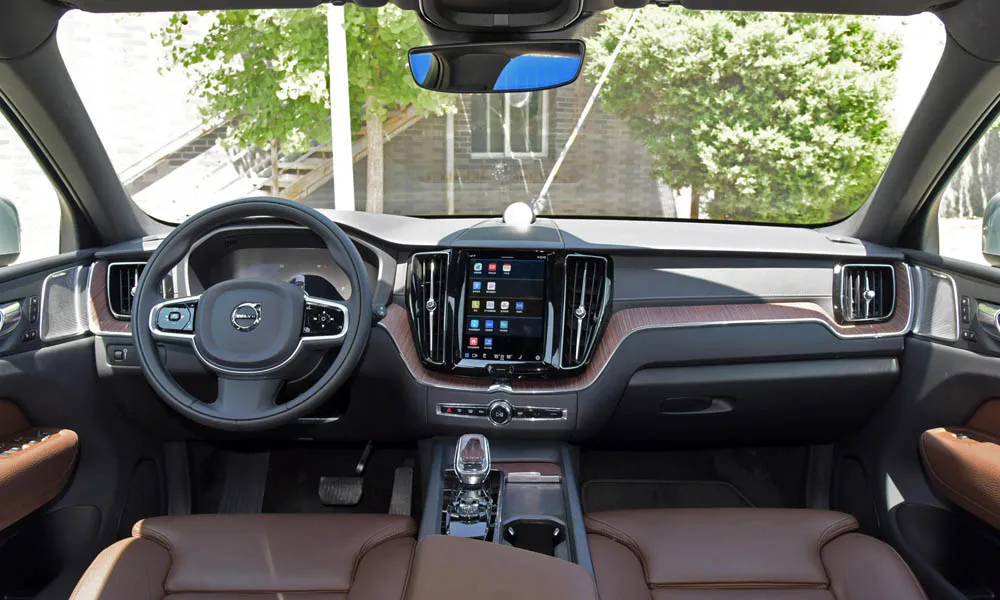 Фото Volvo XC60 — передняя панель. Передняя панель в коричневой отделке: расположение экранов и дефлекторов. Мягкие материалы верхнего яруса и вставки задают уровень интерьера Volvo XC60 — передняя панель