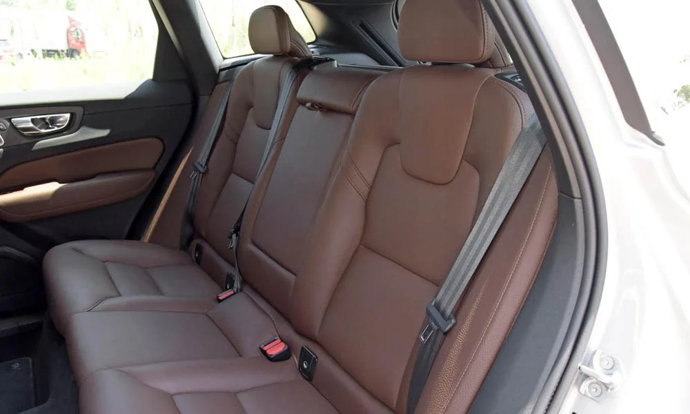 Фото Volvo XC60 — задние сиденья. Второй ряд: профиль дивана, подголовники и обивка из гладкой коже. Плоский пол упрощает посадку втроём Volvo XC60 — задние сиденья