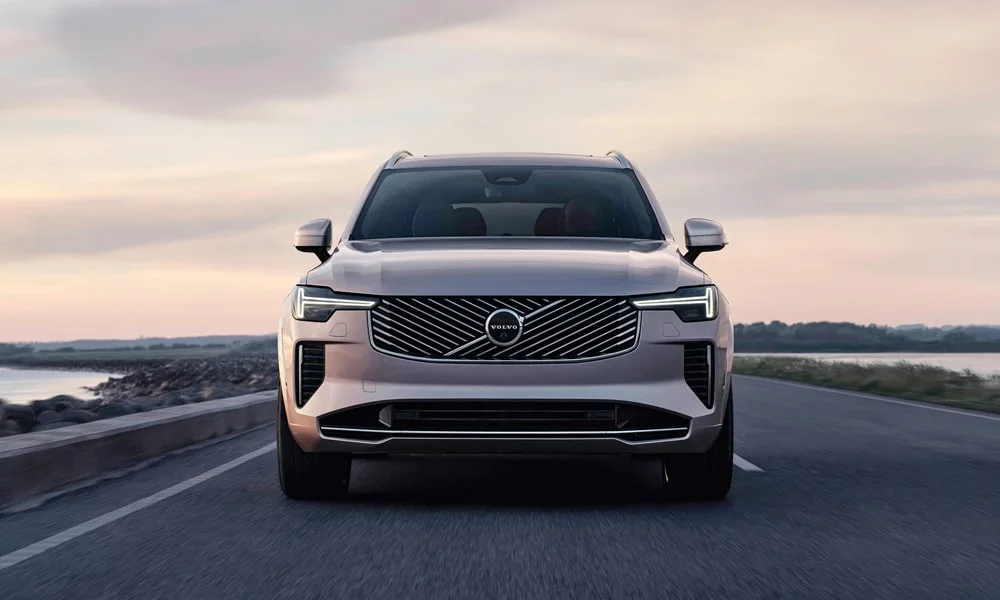 Фото Volvo XC90 (2024) — вид спереди, фото 10. Серебристый кузов, строгая симметрия оптики — базовый ракурс знакомства с дизайном Volvo XC90 (2024) — вид спереди, фото 10